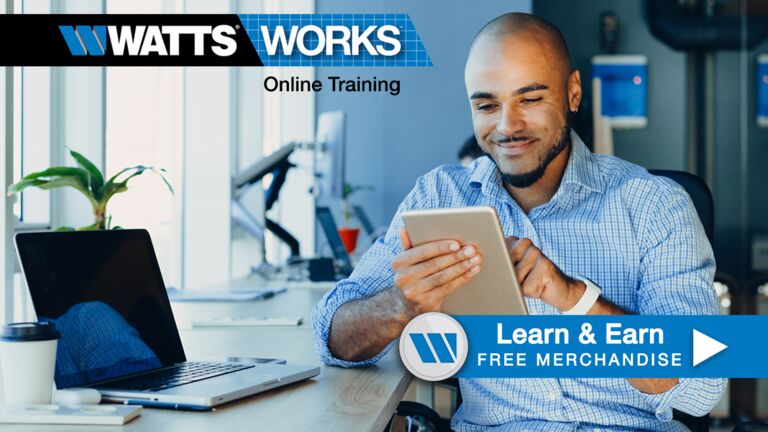 A man at his work desk looking at his iPad to access Watts' Online Training program. A Learn 